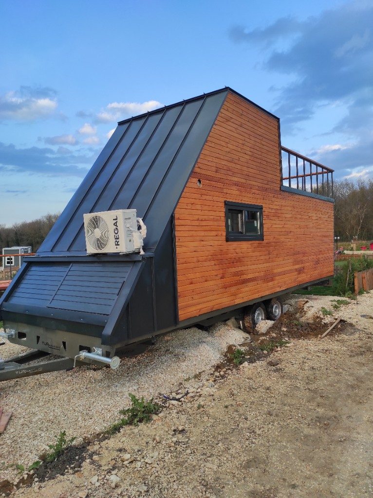 Tekerlekli tiny house — ahşap cephe, metal çatı ve çatı terası
